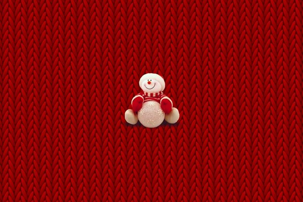 Muñeco de nieve de peluche sobre fondo de mimbre rojo