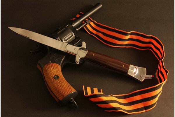 Cuchillo, revólver y cinta de San Jorge en la mesa