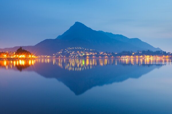 El reflejo de la montaña y las luces de la ciudad en el agua