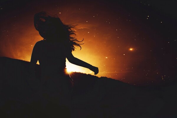 Silueta oscura de una niña al atardecer