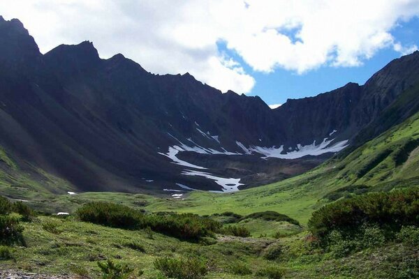 Hermosas montañas y un claro verde