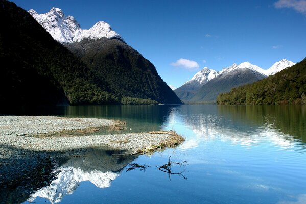 Lago, y alrededor de la montaña con copas de nieve