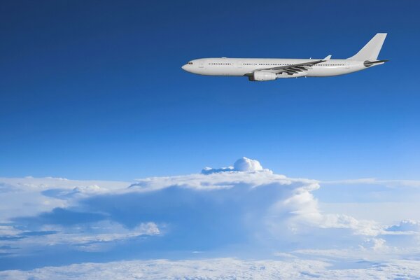 Avión blanco vuela sobre las nubes