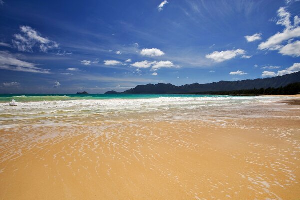Playa de arena contra el cielo azul
