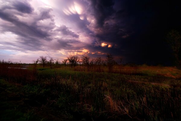 Puesta de sol mágica a través de las nubes en el campo