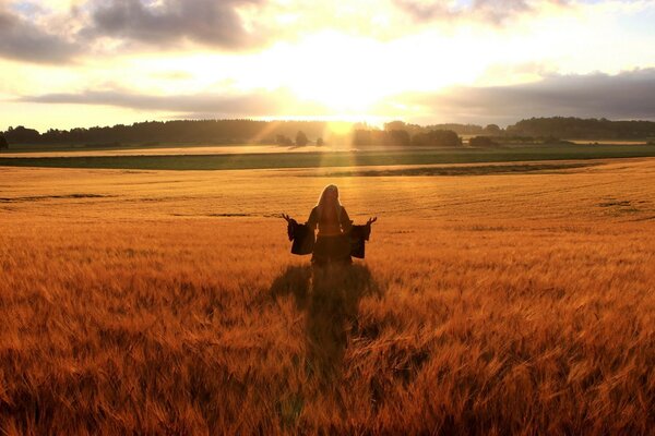 Mujer feliz en un campo de trigo dorado