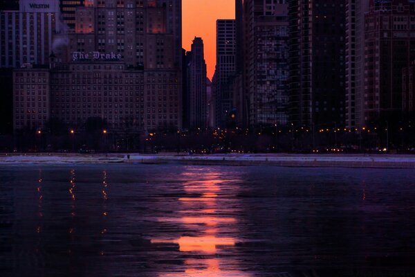 Puesta de sol frente al mar y edificios de gran altura